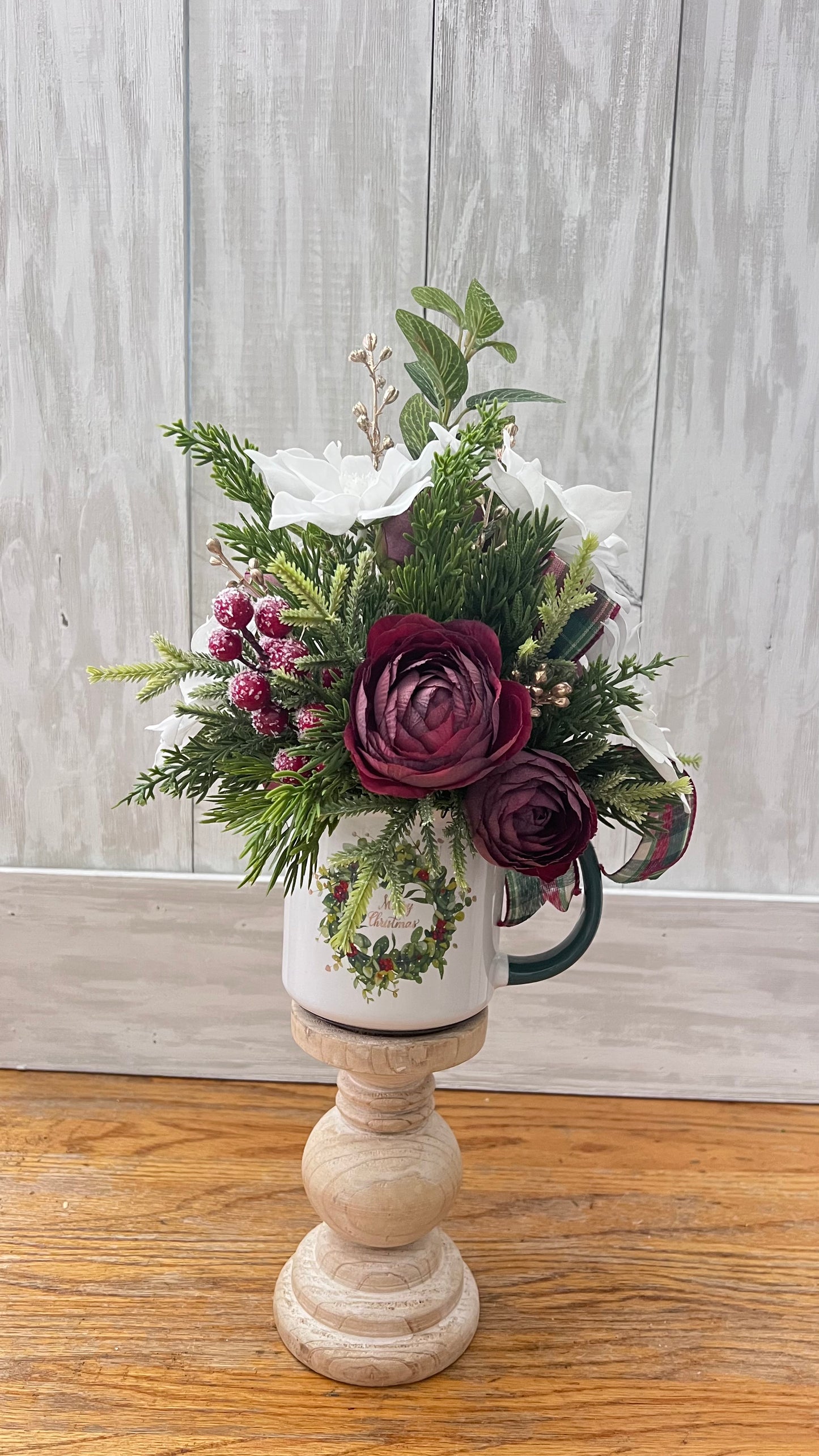 Burgundy ranunculus stems styled in a vertical coffee mug arrangement with greenery and ribbon to demonstrating height, scale, and structural design