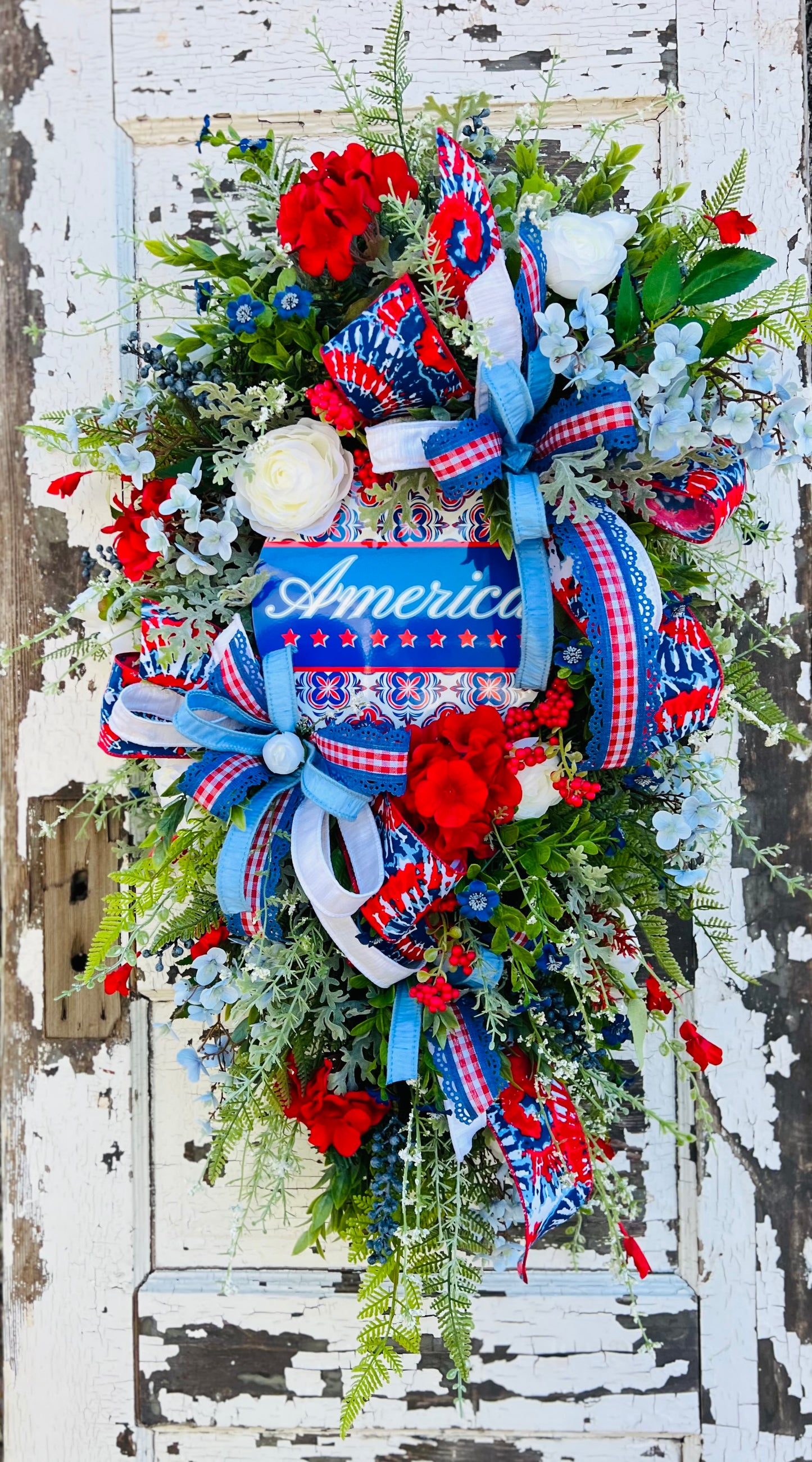 White ranunculus bundle styled in a patriotic wreath with red, white, and blue florals and ribbon accents — Gardenbug Designs