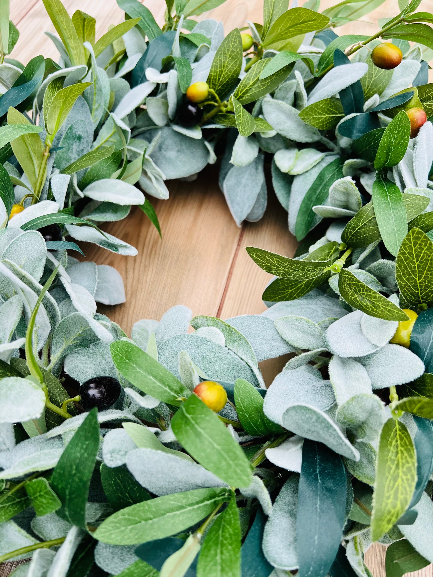 Textural detail showcasing the soft lamb's ear leaves and realistic olive greenery that create the natural look of the First Light everyday greenery wreath