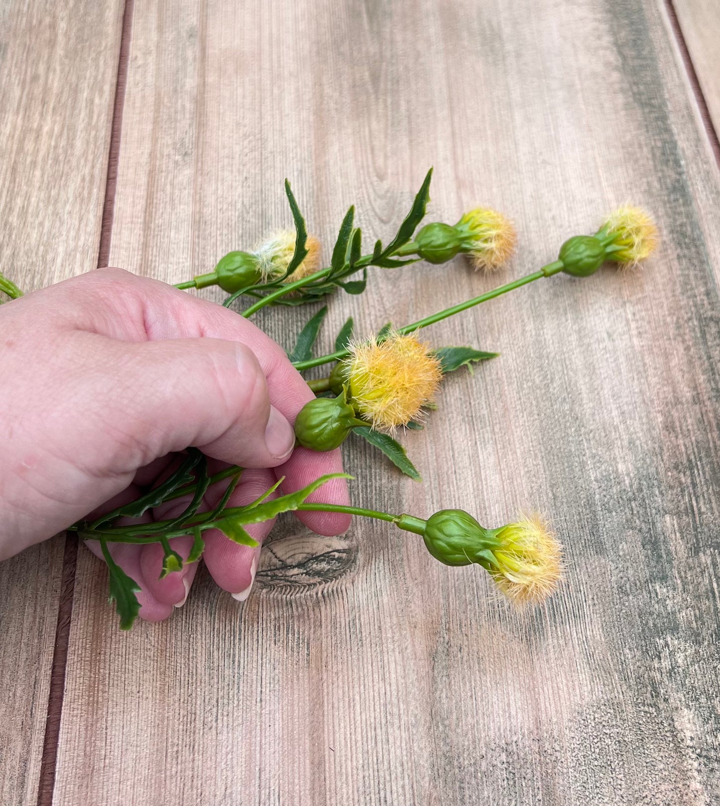 Yellow Meadow Pod Spray shown in hand for scale and sizing reference