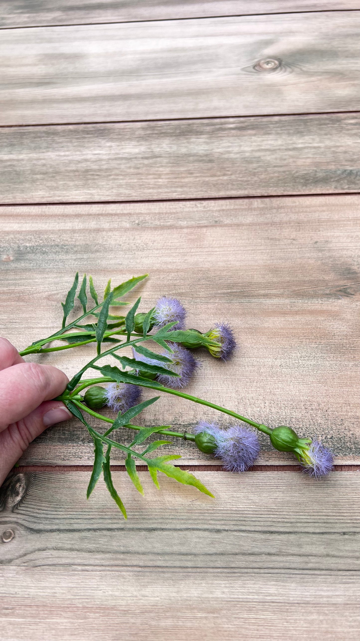 Purple Meadow Pod Spray shown in hand for scale and size reference