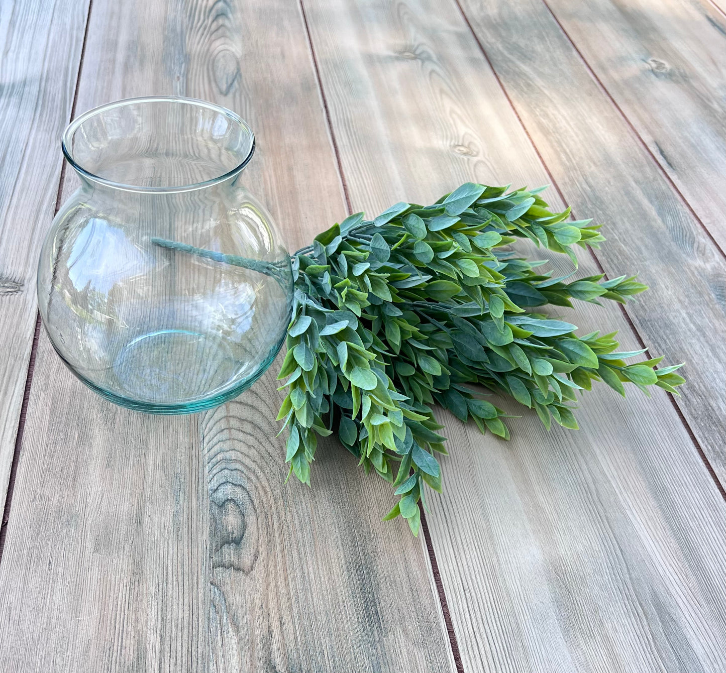 Italian Ruscus Bush arranged on a wooden surface, demonstrating fullness, layering, and its potential in floral design