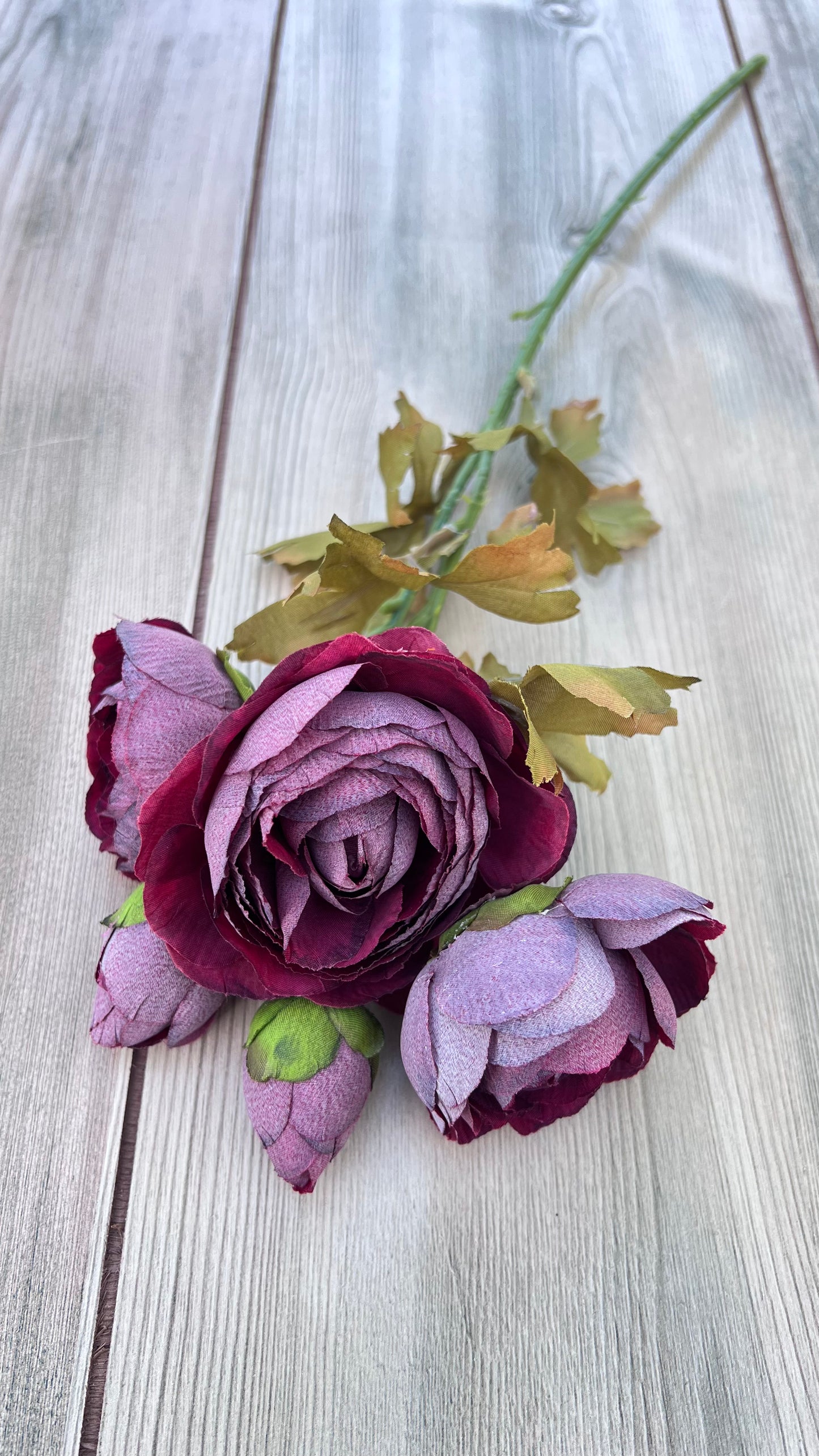 Single stem from the faux Burgundy Ranunculus Bundle showing open bloom, realistic buds, and natural foliage.