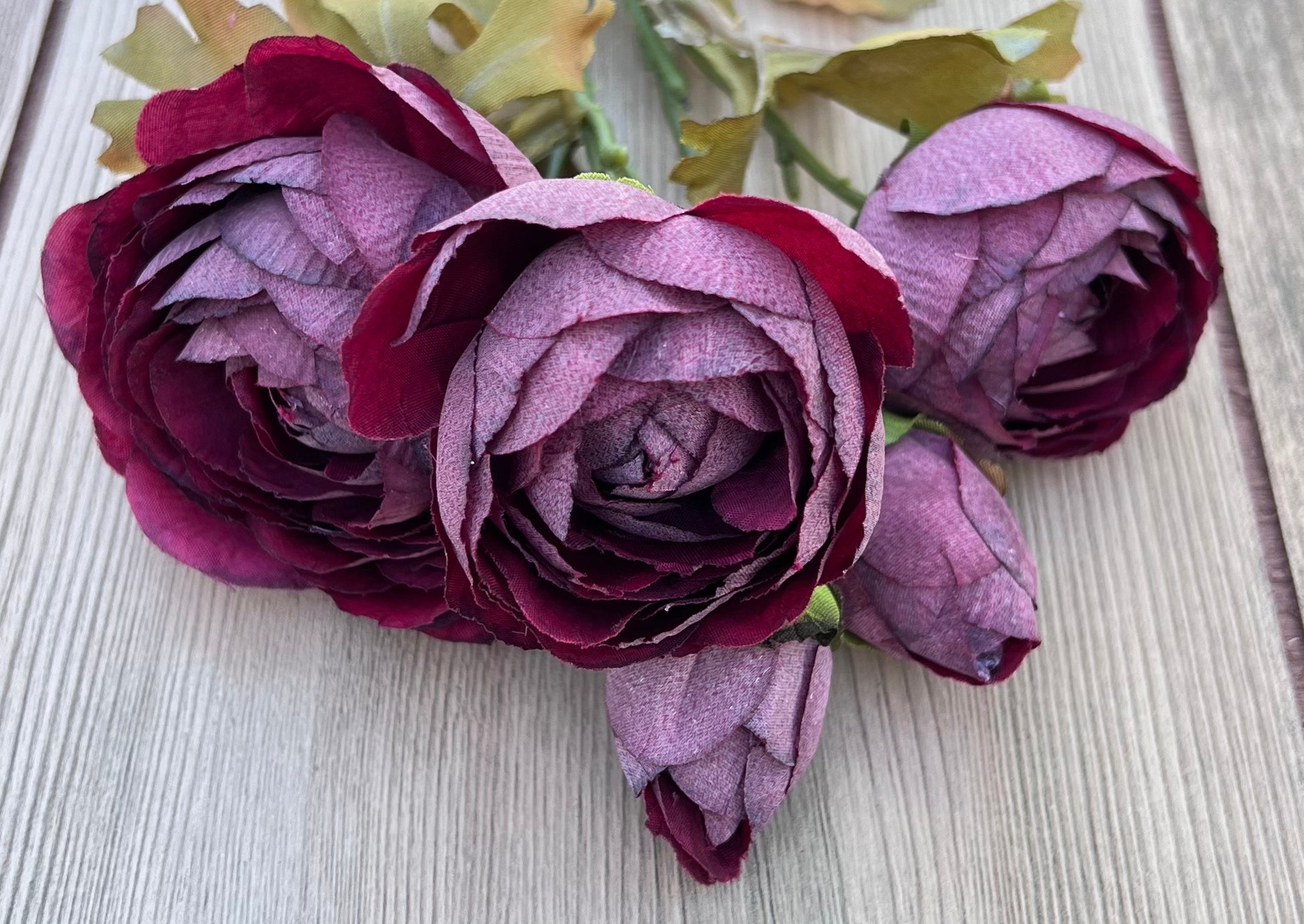 Color detail of faux Burgundy Ranunculus blooms showcasing layered burgundy and plum petals with soft tonal variation and realistic shading.