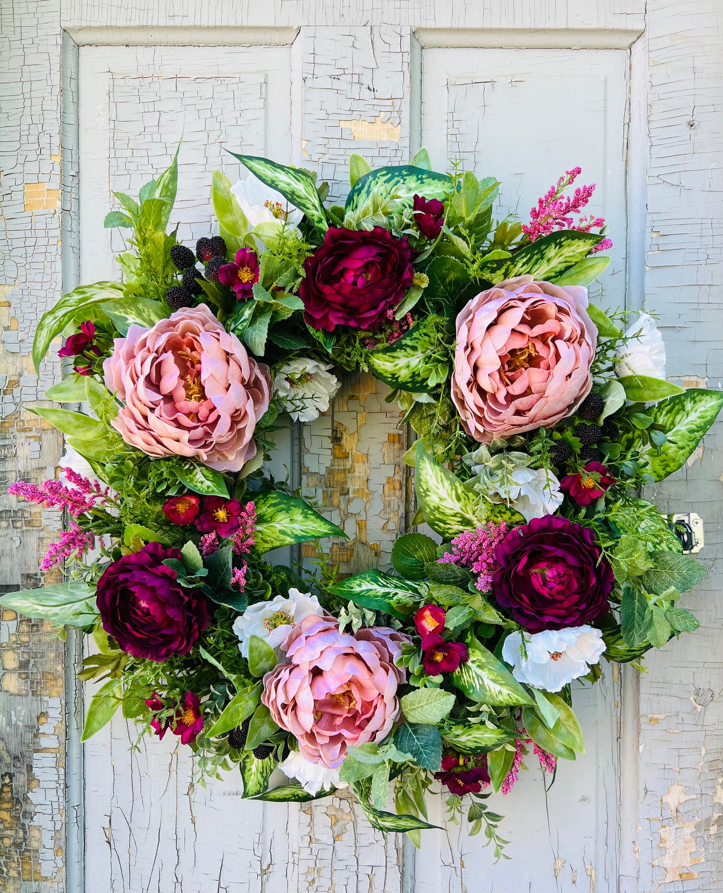 Blackberry Bourbon floral wreath design featuring layered florals, faux blackberries, and realistic greenery arranged in a balanced garden composition and showcased on a vintage door | Gardenbug Designs
