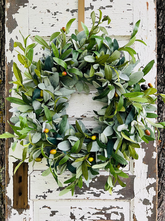 First Light olive and lamb's ear wreath by Gardenbug Designs featuring realistic olive branches with fruit and soft lamb's ear greenery styled on a rustic wooden door