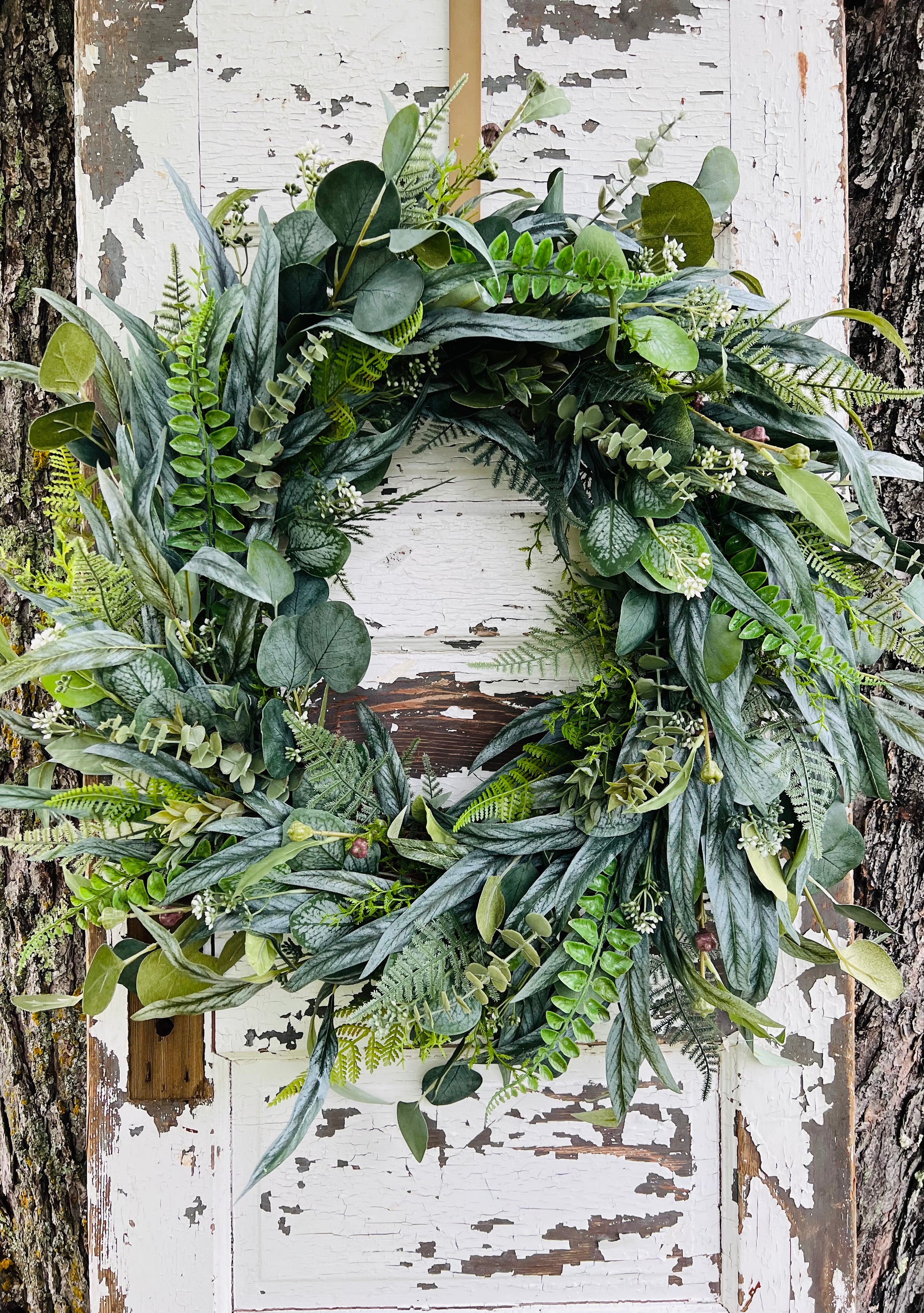 Handcrafted Hartley botanical greenery wreath with layered eucalyptus, fern, and mixed foliage for year round front door decor by Gardenbug Designs.