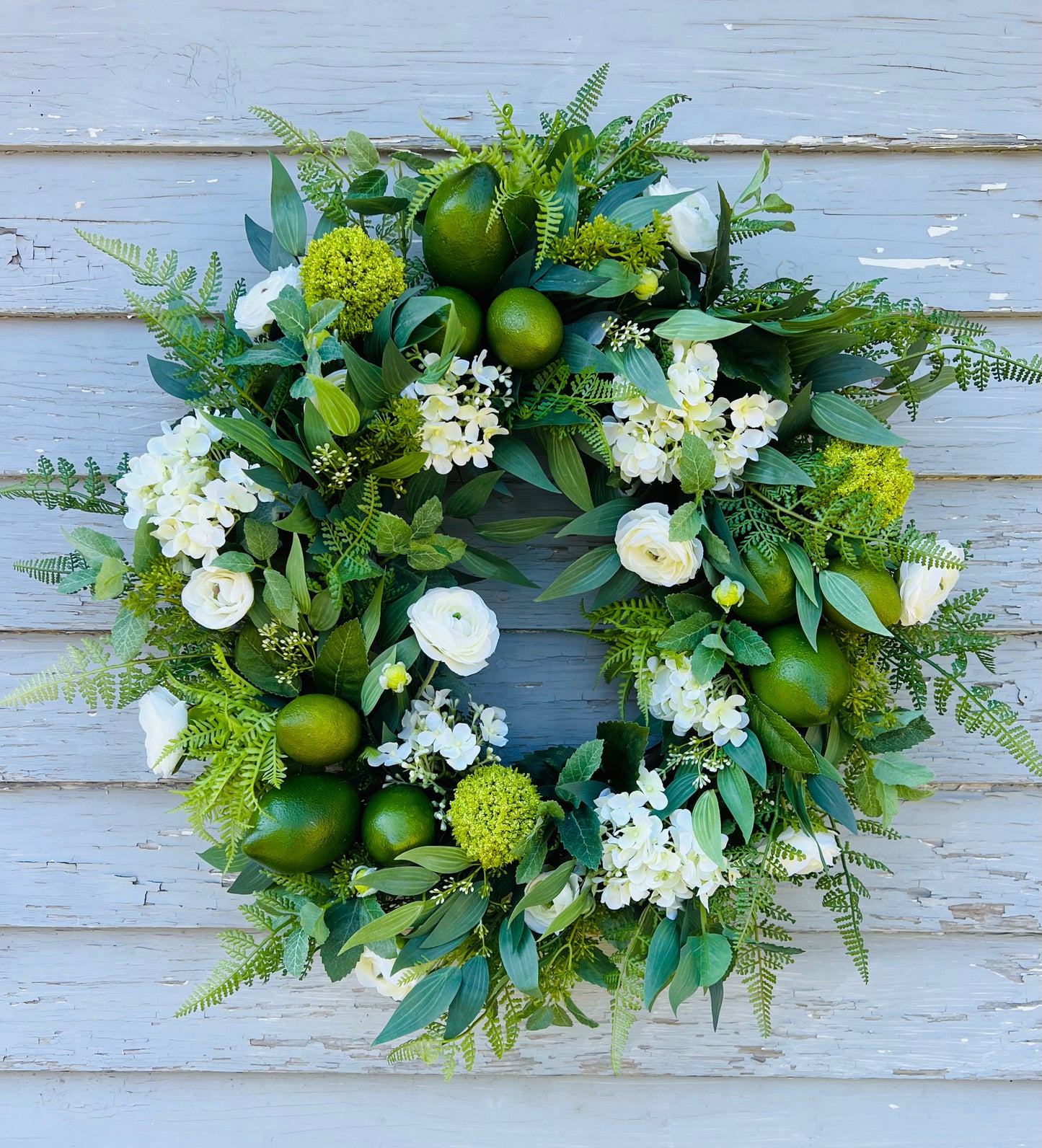 Mojito botanical wreath design featuring realistic greenery and citrus elements displayed on blue exterior siding | Gardenbug Designs