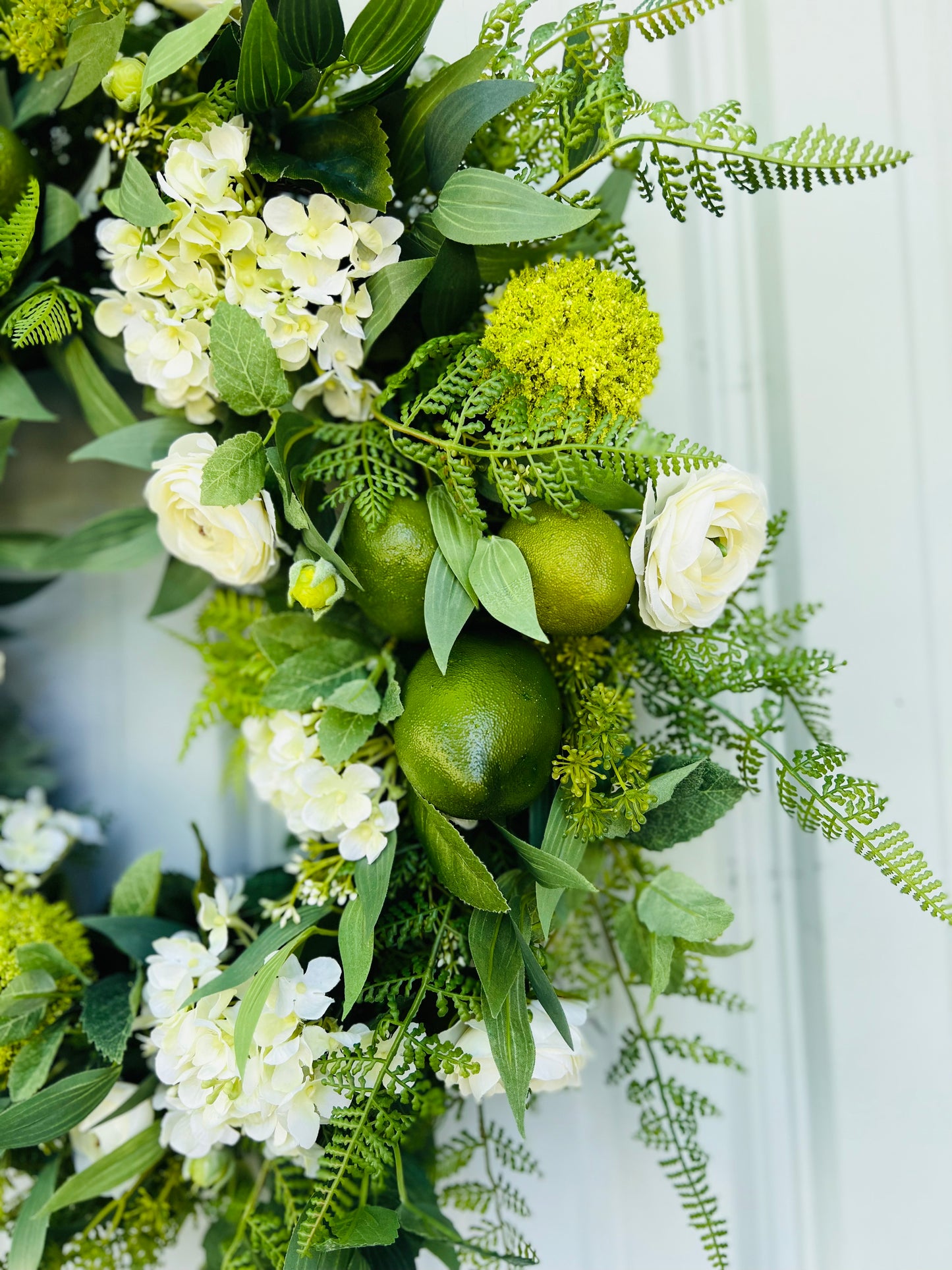 Mojito botanical wreath close-up showing ranunculus, hydrangeas, citrus accents, and realistic greenery textures | Gardenbug Designs