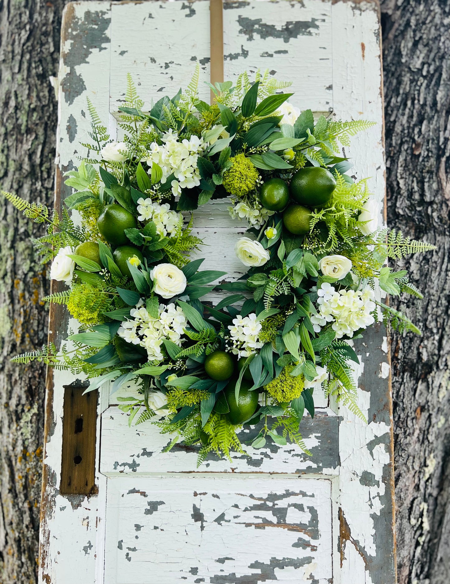 Handcrafted Mojito Botanical wreath with limes, white florals, and lush greenery for summer front door decor by Gardenbug Designs.