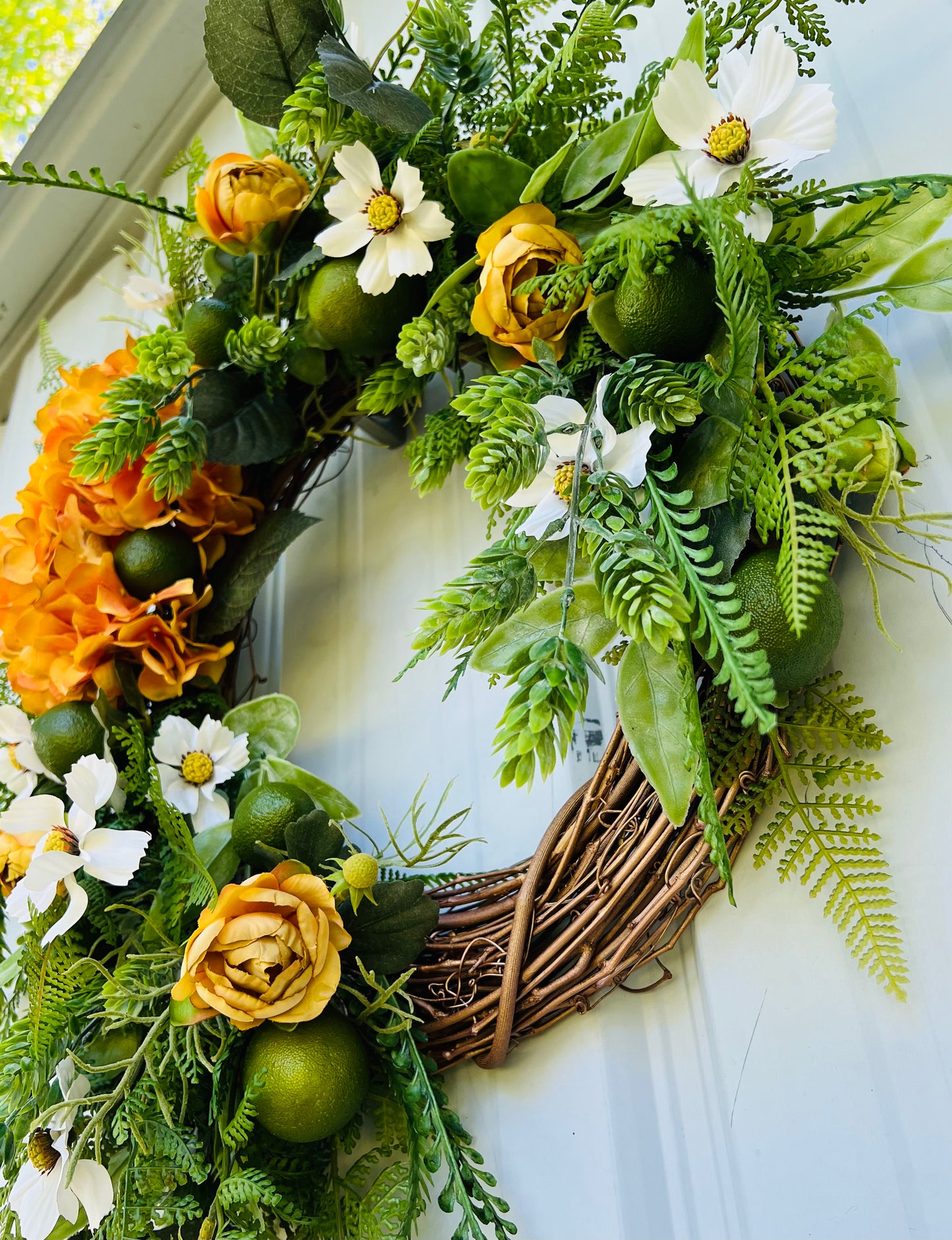 Gardenbug Designs Moscow Mule wreath showing dimensional layering of greenery, citrus accents, and florals on a grapevine base