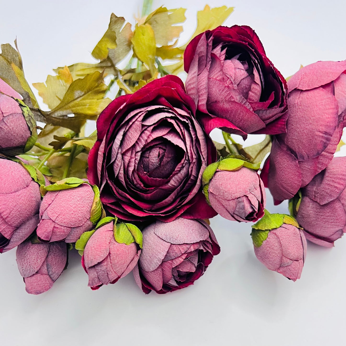 Close-up burgundy ranunculus blooms showcasing layered petals, rich tonal variation, and lifelike texture